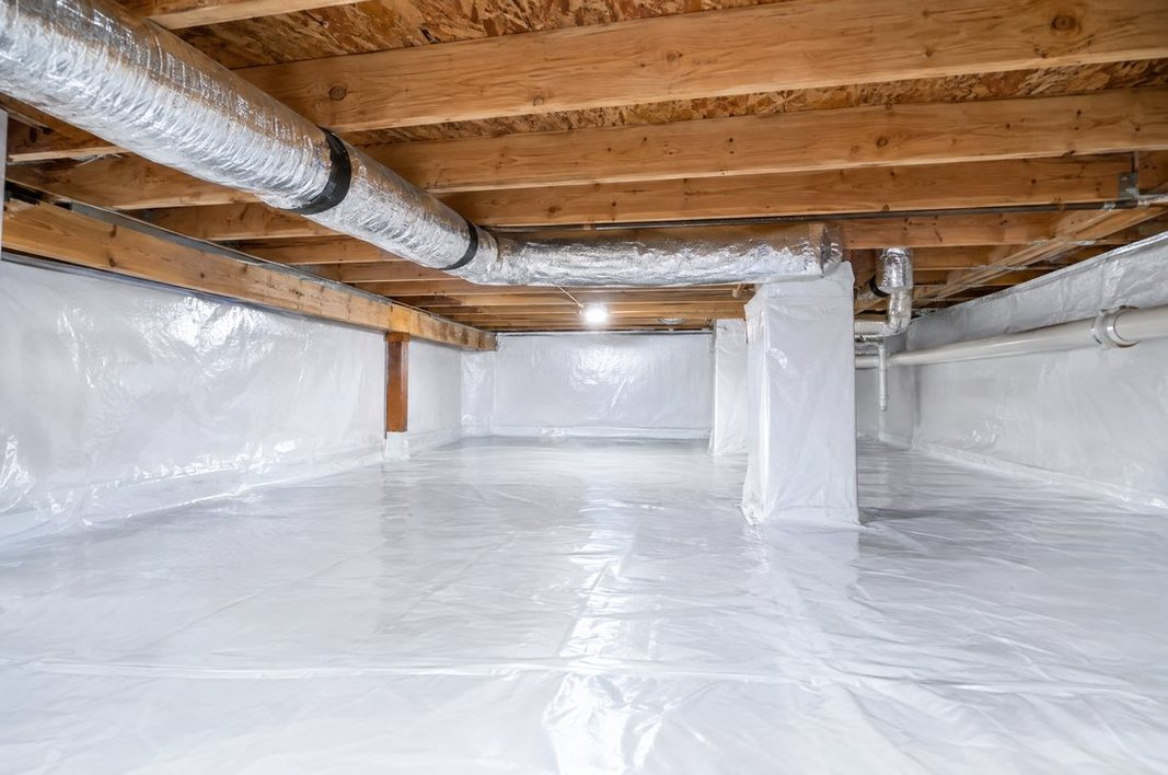 Sealed, encapsulated crawl space with a bright white vapor barrier under a Greenville home